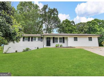 Well-maintained ranch-style home with a lush green lawn and a freshly painted exterior at 6026 S Bear Dr, Douglasville, GA 30135