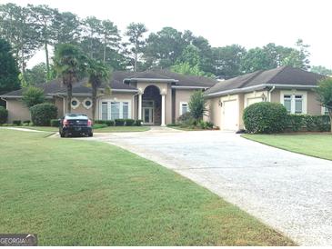 Beautiful home with a well-manicured lawn, circular driveway, and palm trees at 6279 Giles Rd, Lithonia, GA 30058