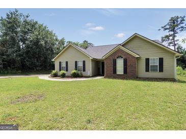 Charming single-story home with green lawn, brick facade, black shutters and manicured landscaping at 321 Harris Ave, Locust Grove, GA 30248