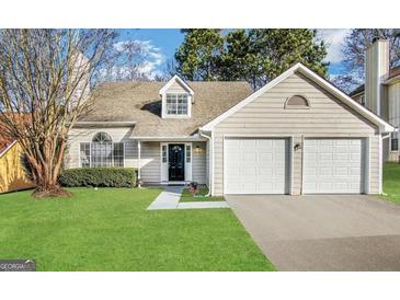 Charming one-story home featuring a two-car garage, well-maintained lawn, and traditional architectural details at 3228 Rivermist Cv, Decatur, GA 30034