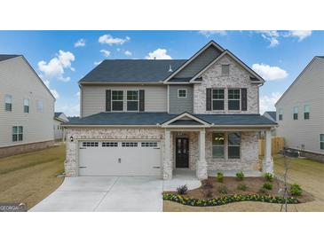 Charming two-story home with a brick facade, covered porch, and a well-manicured lawn at 675 Edgar St, Hampton, GA 30228