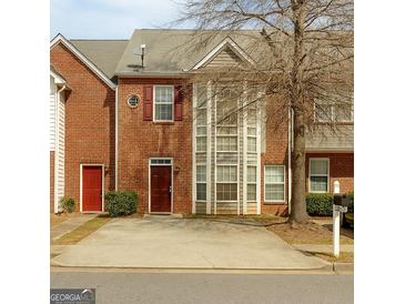 Brick townhouse with a concrete driveway and a large window at 7112 Brookview Way, Riverdale, GA 30274
