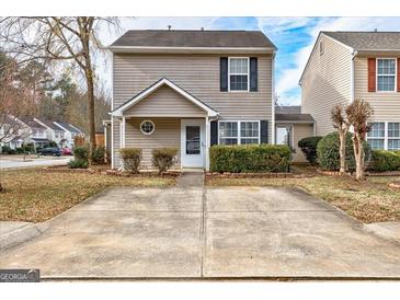 Charming two-story home featuring neutral siding, black shutters, manicured landscaping, and a concrete driveway at 103 Watercress Ct, Stockbridge, GA 30281