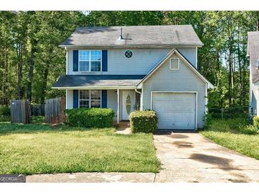 Two-story home featuring charming blue shutters, an attached garage, and a well-maintained lawn at 131 Turning Pt, Stockbridge, GA 30281