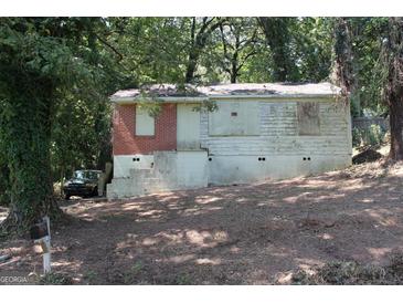 Exterior of single-story home with weathered siding, a brick facade, and greenery at 346 Schoen Se St, Atlanta, GA 30315