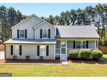 Charming two-story home with a manicured lawn and gray siding at 303 Mill Glen Ct, Mcdonough, GA 30252