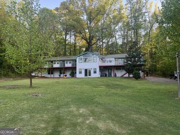 Charming multi-story home boasting a large yard, mature trees, and a full length balcony at 2316 Emerald Dr, Jonesboro, GA 30236