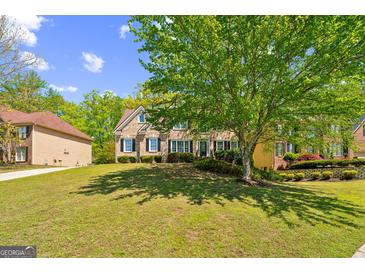 Lovely brick home featuring a large lawn and a mature tree providing ample shade at 1201 Turtle Creek Ct, Lawrenceville, GA 30043