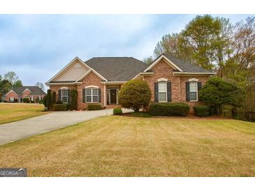 Charming single-story brick home with well-manicured lawn and a paved driveway leading to a welcoming entrance at 118 Jasmine Way, Villa Rica, GA 30180