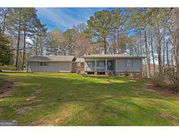Charming single-story home with a large front yard surrounded by mature trees, offering a serene and private setting at 150 Mary Lynn Ln, Fayetteville, GA 30214