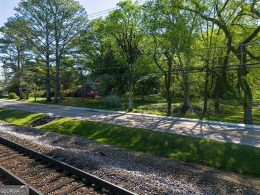 A pleasant street view featuring mature trees, and a glimpse of charming homes in a serene residential area at 174 E Broad St, Fairburn, GA 30213