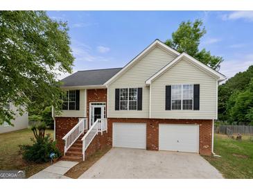 Charming two-story home with brick and siding exterior, two-car garage, and manicured landscaping at 8103 Rhodes Way, Riverdale, GA 30274