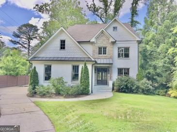 Charming two-story home with a stone and painted brick exterior and well-manicured front lawn at 906 Winall Down Ne Rd, Atlanta, GA 30319