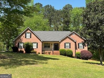 Charming brick home with a well-manicured lawn and mature trees in a serene setting at 75 The Farm Rd, Mcdonough, GA 30252