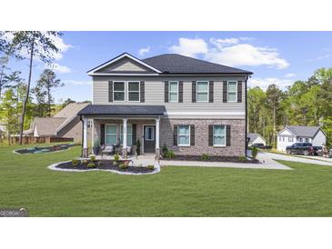 Charming two-story home featuring gray siding, brick accents, and a welcoming front porch with elegant columns at 924 Bryson Lake Cir, Douglasville, GA 30134