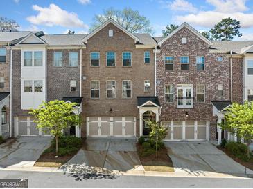 Charming brick townhome featuring an attached garage, well maintained landscaping, and stylish curb appeal at 1341 Rosen Rd, Brookhaven, GA 30319