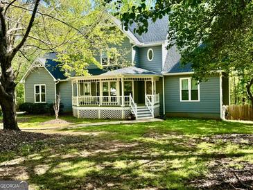 Charming gray home featuring a welcoming front porch and well-maintained lawn at 149 Wimberly Way, Powder Springs, GA 30127