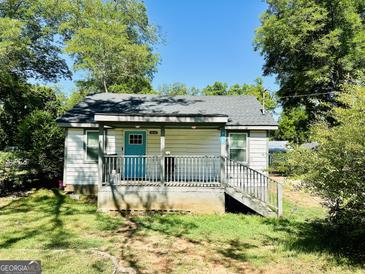 Charming single-story home with a covered porch and inviting blue front door at 2232 Lee Sw St, Covington, GA 30014