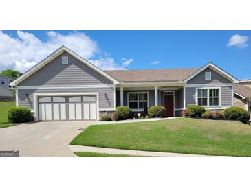 Charming single-story home with well-manicured lawn, landscaping and attached two car garage at 1598 Renaissance Ne Dr, Conyers, GA 30012