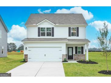 Two-story home featuring an attached garage, black shutters and a manicured lawn on a sunny day at 295 Limestone Circle, Conyers, GA 30013
