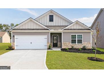 Charming single-Gathering home with a well-manicured lawn and a two-car garage on a sunny day at 299 Limestone Circle, Conyers, GA 30013