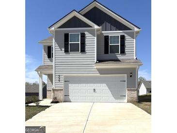 Two-story home featuring a two-car garage and modern gray siding with contrasting black shutters and trim at 458 Prescott Way, Villa Rica, GA 30180