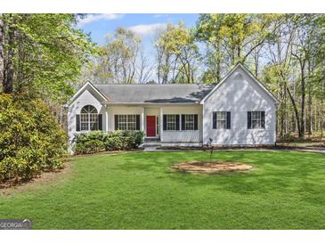 Charming single-story home with a well-manicured lawn and a welcoming red front door at 185 Cold Harbor Ct, Sharpsburg, GA 30277