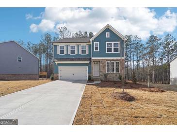 Charming blue two-story home with stone accents and attached two-car garage at 7260 Eton Ln, Locust Grove, GA 30248