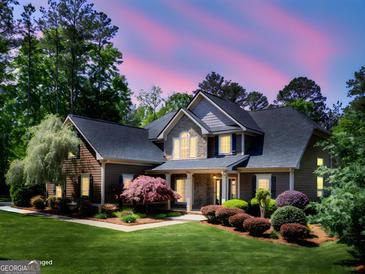 Stunning two-story home with manicured lawn and professional landscaping at twilight at 249 Suffolk Way, Mcdonough, GA 30252