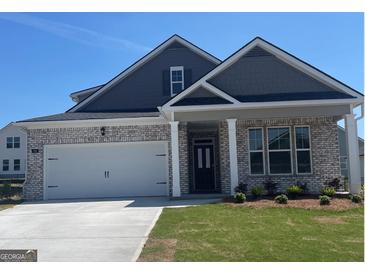 Charming brick home featuring a two-car garage and well-manicured lawn at 591 Parnassus Rd, Locust Grove, GA 30248