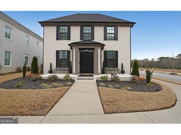 Charming two-story brick home featuring a landscaped yard, covered entrance, and black window shutters at 1461 Thomas St, Conyers, GA 30094