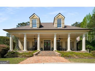 Stately home featuring columns, dormer windows, a symmetrical facade and a welcoming brick walkway and expansive porch at 240 Trotters Rdg, Fayetteville, GA 30215