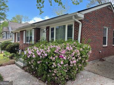 Charming brick home featuring a well-maintained yard with beautiful flowering shrubs at 2980 Catalina Dr, Decatur, GA 30032