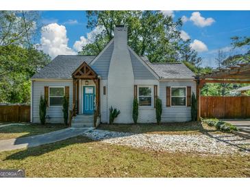 Charming home with bright blue door, white brick chimney, and lush greenery at 3164 Harris Dr, East Point, GA 30344