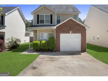 Charming two-story home with attached brick garage and well-maintained landscaping, curb appeal at 7756 Newbury Dr, Jonesboro, GA 30236