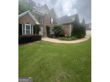 Charming brick home with well-manicured landscaping, flower beds and a walkway leading to the front door at 45 Anna Dr, Covington, GA 30014