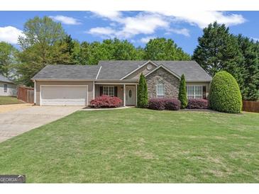 Charming single-story home with stone accents, lush lawn, and manicured landscaping at 421 Bear Cub Path, Social Circle, GA 30025
