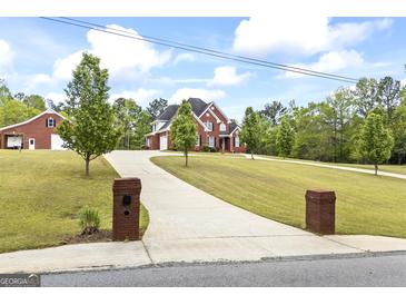 Beautiful brick home with well-manicured lawn, long driveway, and separate garage at 2351 Rabbit Farm Cir, Loganville, GA 30052
