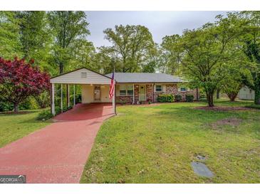Charming brick home featuring a covered carport and a well-maintained front lawn at 6950 Shannon Dr, Lithia Springs, GA 30122