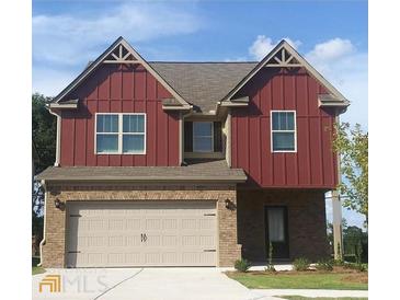 Charming two-story home with brick and red siding, featuring an attached two-car garage at 316 Trulove Lane Lot 35 # 35, Locust Grove, GA 30248