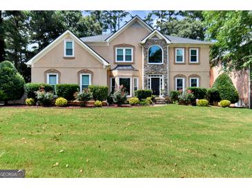 Stunning two-story home with lush landscaping and a stone accented entryway in a desirable neighborhood at 4335 Burgomeister Pl, Snellville, GA 30039