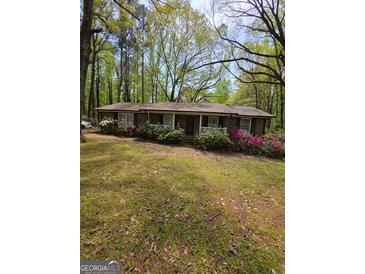 Charming single-story brick home with mature trees and colorful landscaping at 5730 Koweta Rd, South Fulton, GA 30349