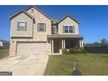 Charming two-story home with a brick and siding exterior, attached garage, and well-manicured lawn at 375 Madison Grace Ave, Mcdonough, GA 30252