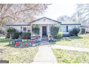 Charming single-story home with front yard and sidewalk leading to entryway at 30 Millwood Dr, Covington, GA 30016