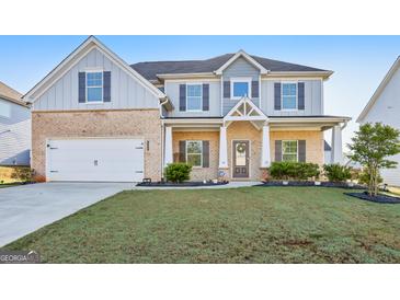 Charming two-story home featuring a well-manicured lawn, brick accents, and a welcoming front porch at 255 Orchid Dr, Mcdonough, GA 30252