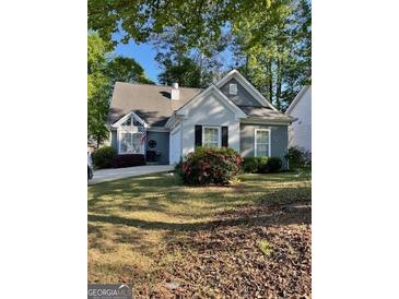 Charming one-story home with grey siding, complemented by well-maintained landscaping and flowering bushes at 411 Sherrels Frd, Peachtree City, GA 30269