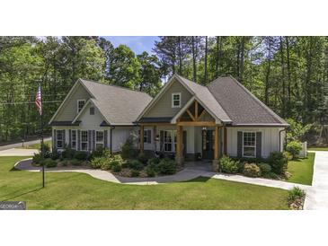 Charming single Gathering home with a manicured lawn, stone walkway and covered porch with timber detailing at 5133 Woodmond Dr, Villa Rica, GA 30180