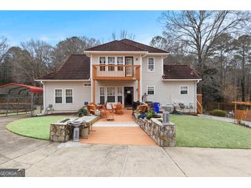 Spacious home featuring a private deck with outdoor seating and a landscaped yard at 5141 Dixie Lake Rd, Union City, GA 30291