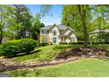 Charming traditional two-story home with lush landscaping and a well-manicured lawn at 102 Santolina Park, Peachtree City, GA 30269