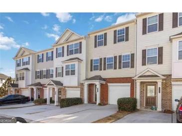 Charming townhomes featuring a brick and siding facade, individual garages, and well-maintained landscaping at 6806 Blackstone Pl # 12, Mableton, GA 30126